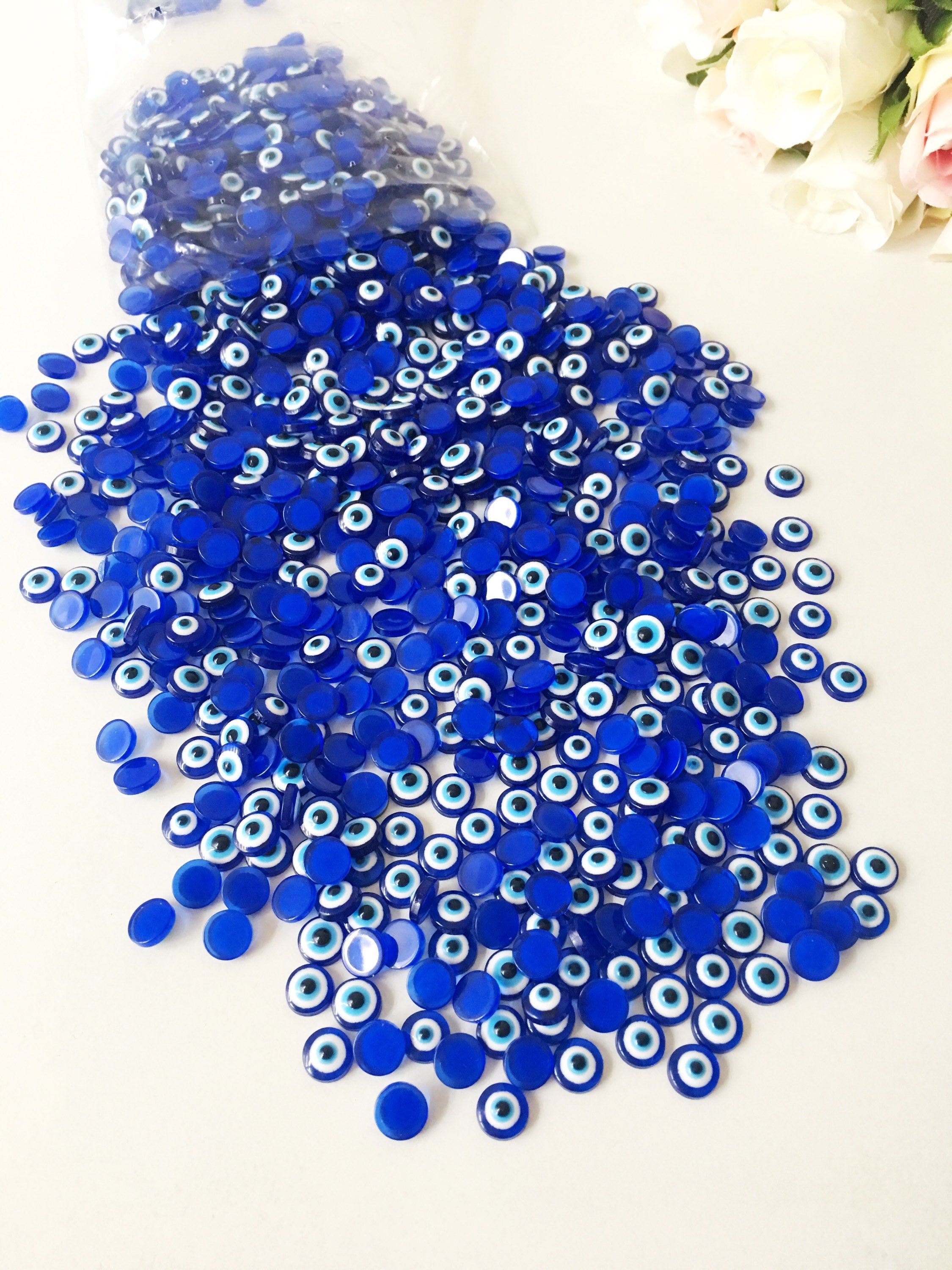 A pack of 20 blue 8mm evil eye cabochons made from resin, showcasing their vibrant color and protective symbol.