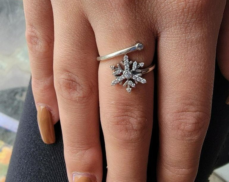 A beautiful .925 sterling silver adjustable ring featuring a snowflake design adorned with sparkling cubic zirconia accents.