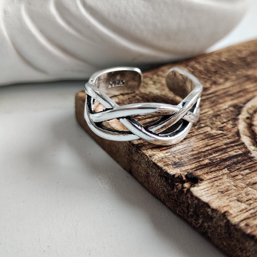 A stunning 925 silver chunky cuff ring featuring a twisted cross braid design, showcasing its intricate craftsmanship and lustrous finish.