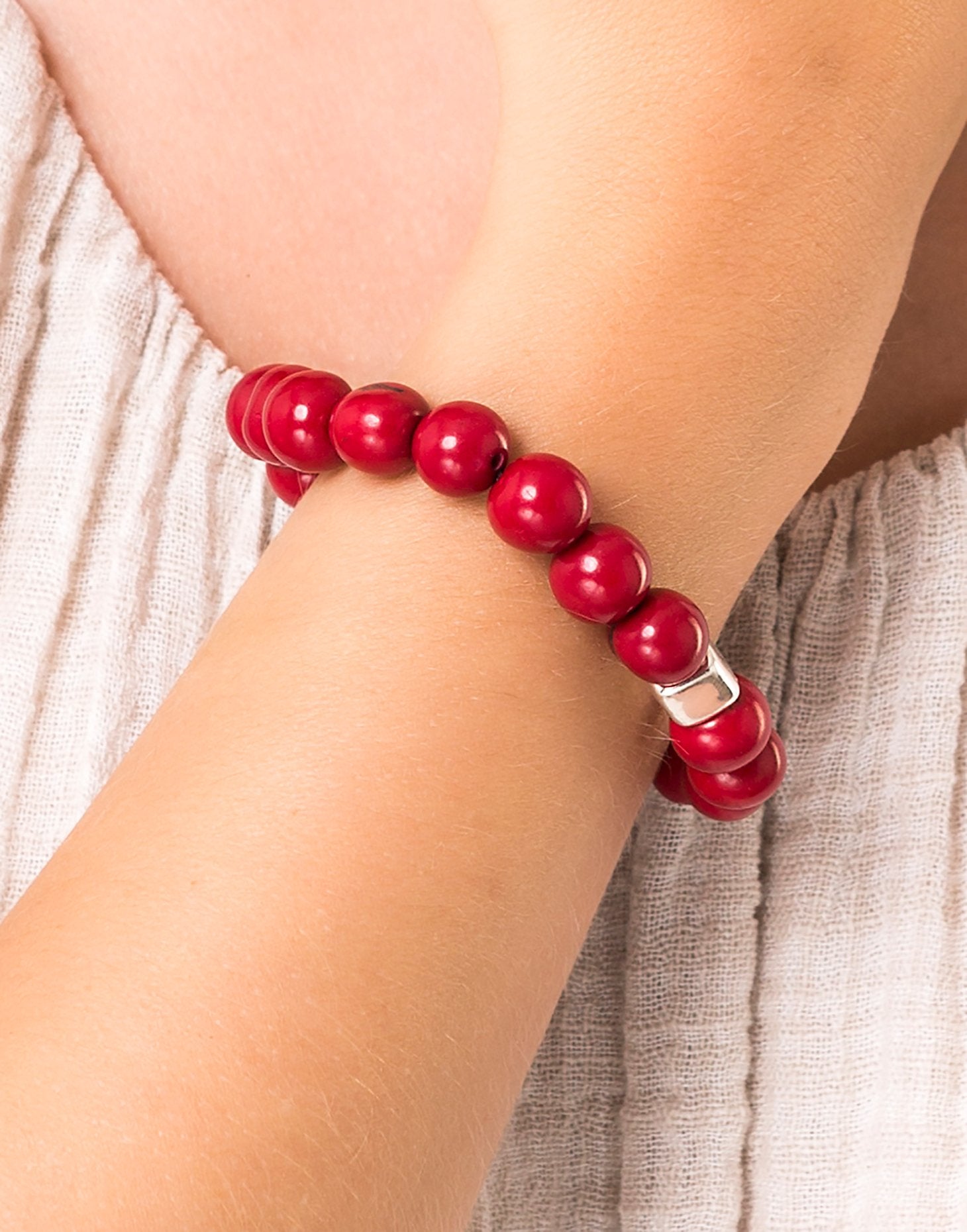A collection of Acai Berry Bracelets in warm colours, showcasing organic materials and silver plated cubes, elegantly displayed in eco-friendly packaging.
