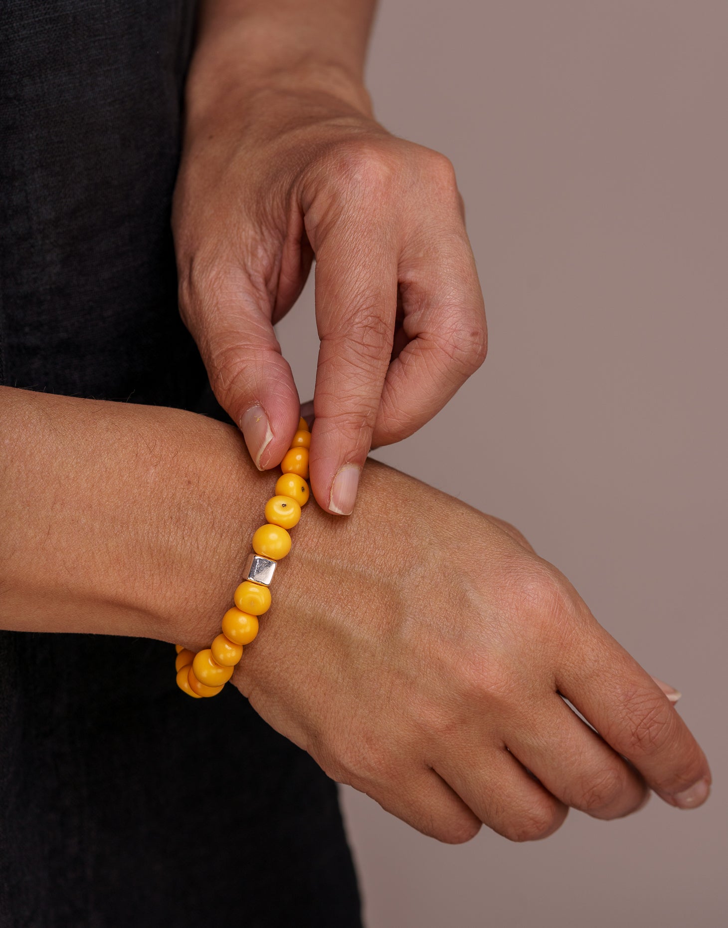 A collection of Acai Berry Bracelets in warm colours, showcasing organic materials and silver plated cubes, elegantly displayed in eco-friendly packaging.