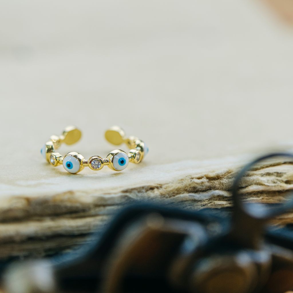 Adjustable blue and white evil eye protection slim stacking ring, crafted from quality metal alloy with a modern minimalist design.