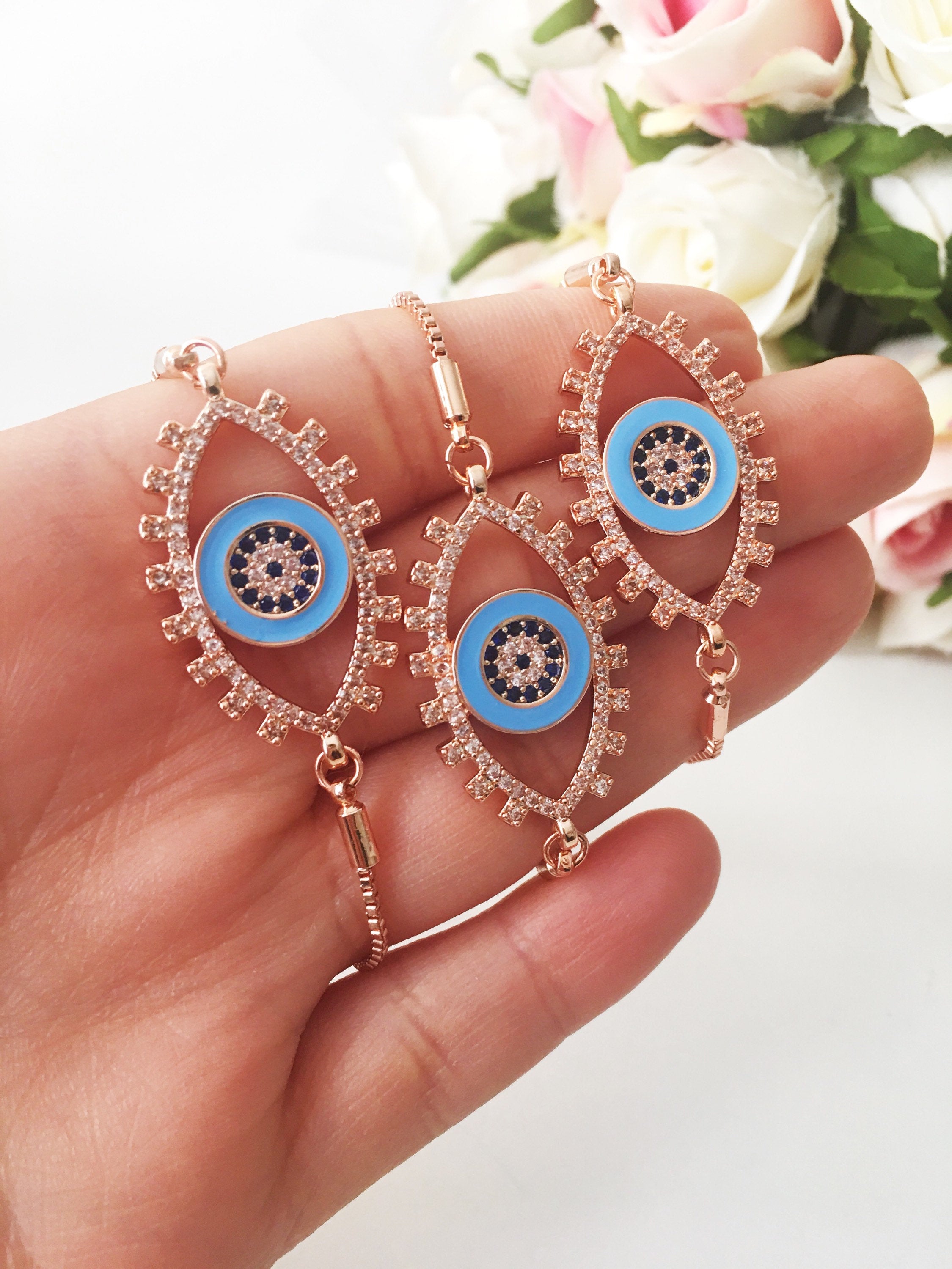 Adjustable Evil Eye Bracelet in rose gold featuring a blue eye charm and zircon accents, showcasing its handmade craftsmanship.