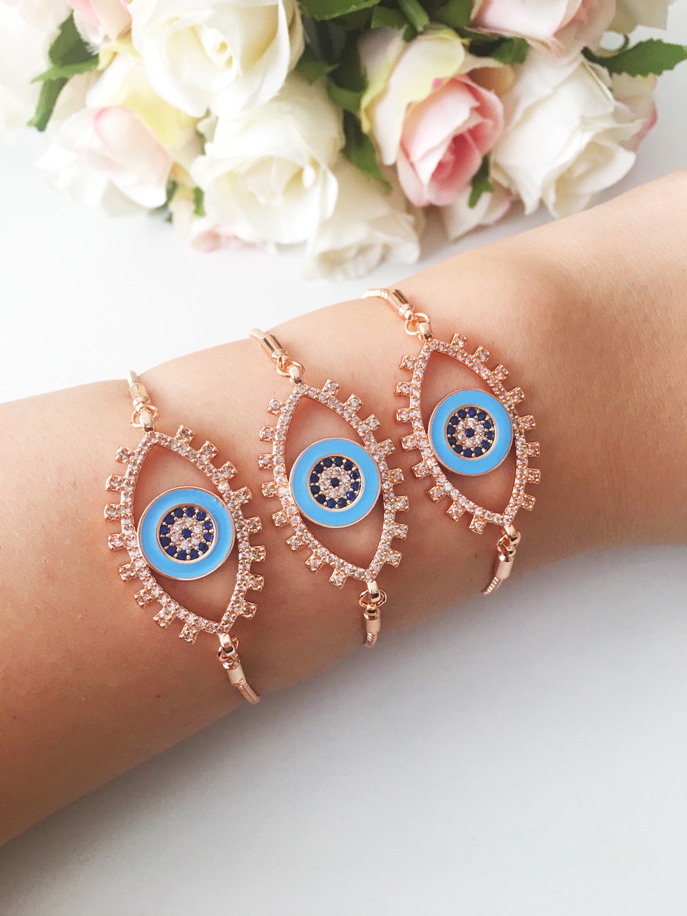 Adjustable Evil Eye Bracelet in rose gold featuring a blue eye charm and zircon accents, showcasing its handmade craftsmanship.