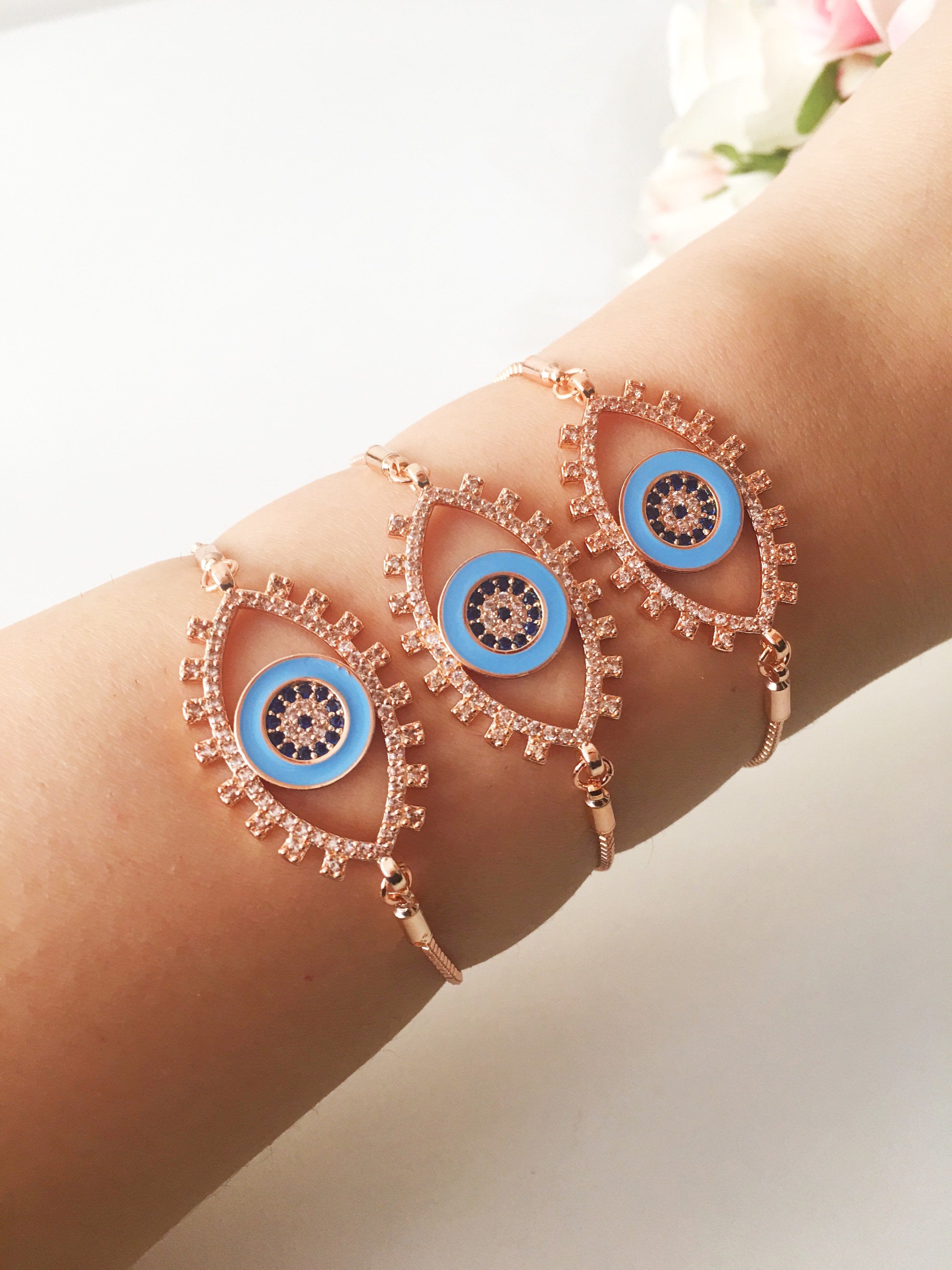 Adjustable Evil Eye Bracelet in rose gold featuring a blue eye charm and zircon accents, showcasing its handmade craftsmanship.