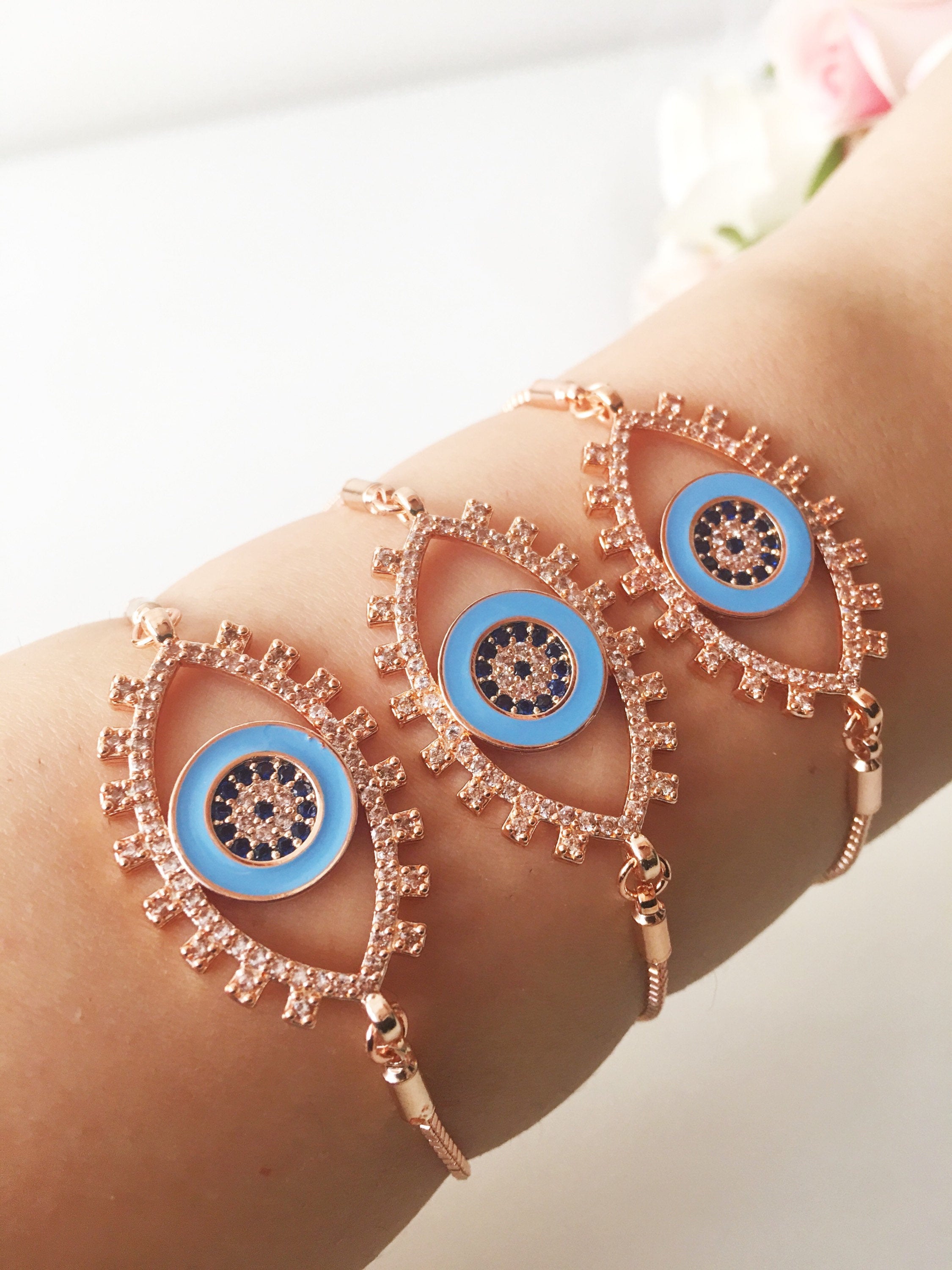 Adjustable Evil Eye Bracelet in rose gold featuring a blue eye charm and zircon accents, showcasing its handmade craftsmanship.
