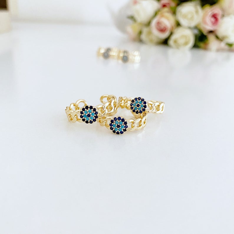 Adjustable evil eye ring featuring a gold curb chain and zirconia beads, showcasing a stylish and protective design.