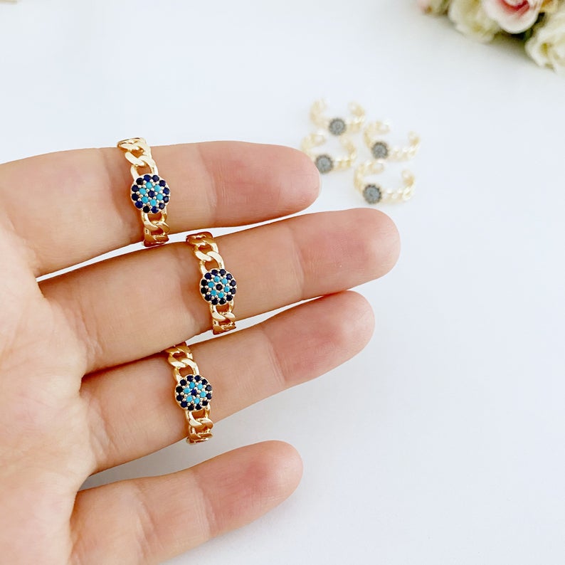 Adjustable evil eye ring featuring a gold curb chain and zirconia beads, showcasing a stylish and protective design.