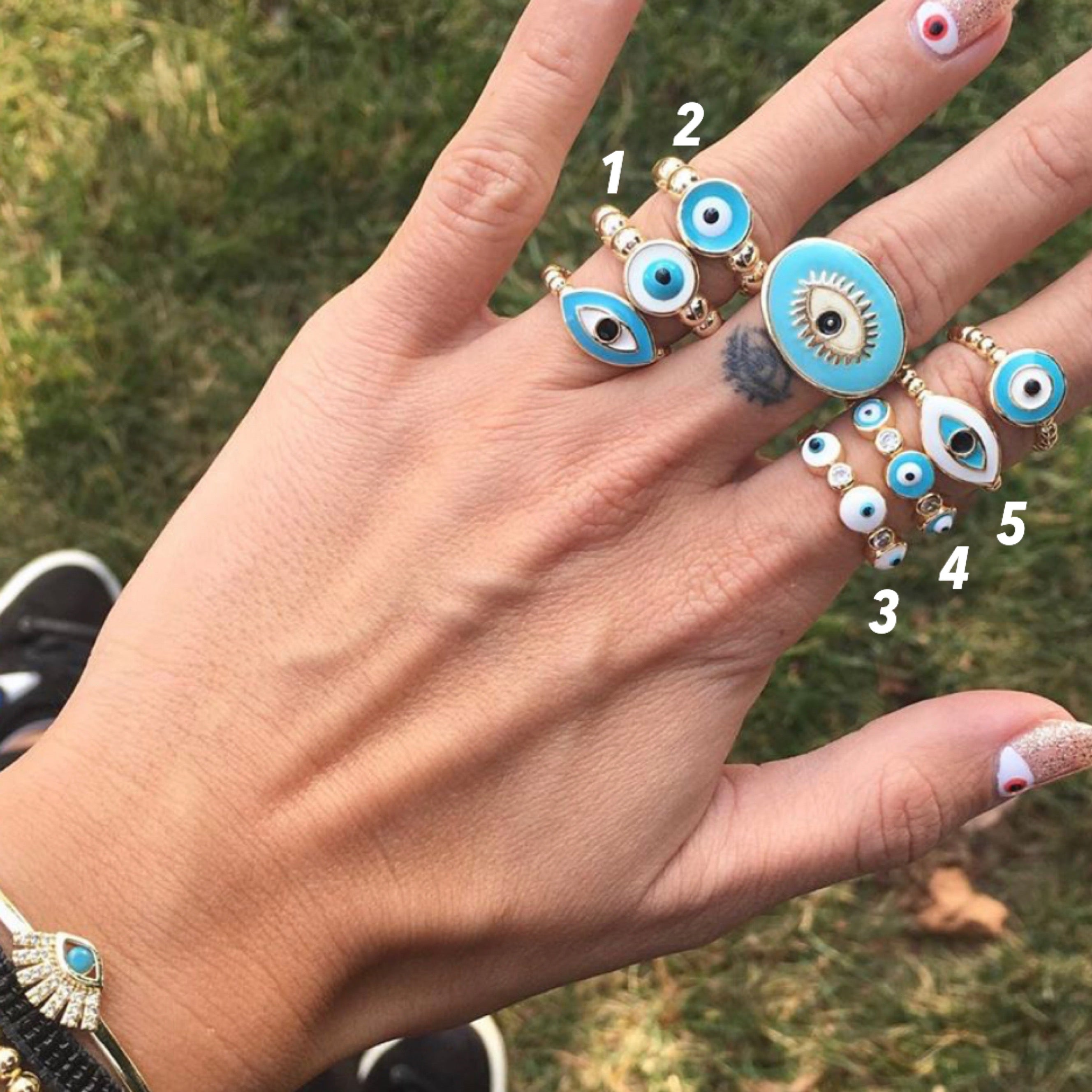 Adjustable evil eye ring featuring a minimalist design with blue and white evil eye motifs on a rose gold or gold band.