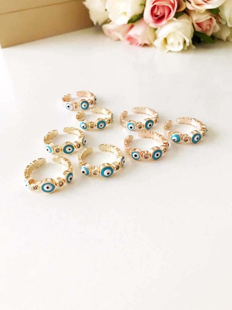 Adjustable evil eye ring featuring a minimalist design with blue and white evil eye motifs on a rose gold or gold band.