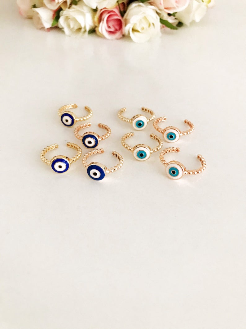 Adjustable evil eye ring featuring blue and white beads on a gold band, symbolizing protection and style.