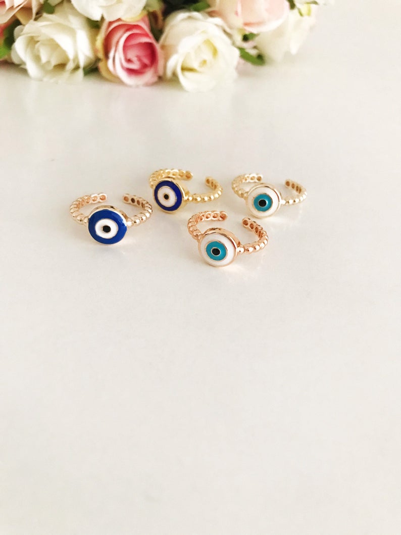 Adjustable evil eye ring featuring blue and white beads on a gold band, symbolizing protection and style.