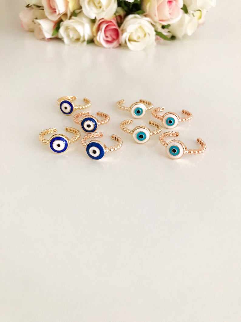 Adjustable evil eye ring featuring blue and white beads on a gold band, symbolizing protection and style.