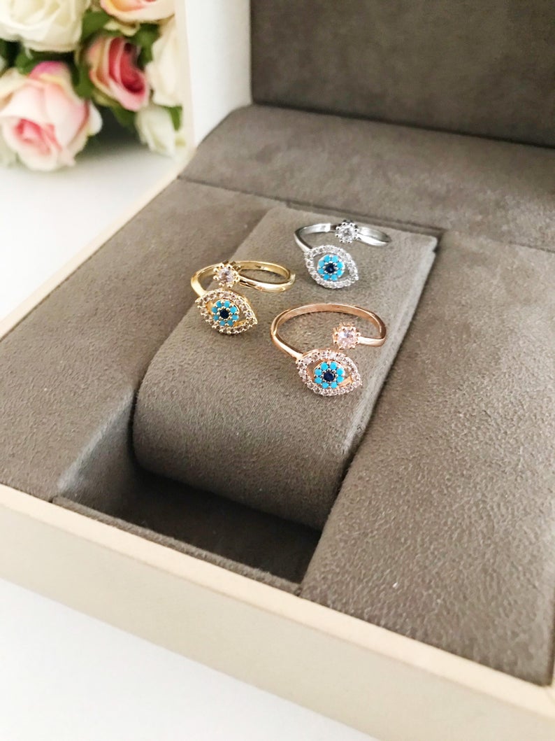 Adjustable Evil Eye Ring featuring a zircon charm in rose gold, showcasing its minimalist design and adjustable band.