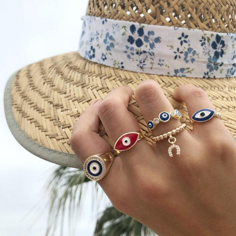 A collection of adjustable gold rings featuring various evil eye designs, showcasing their unique styles and charm.