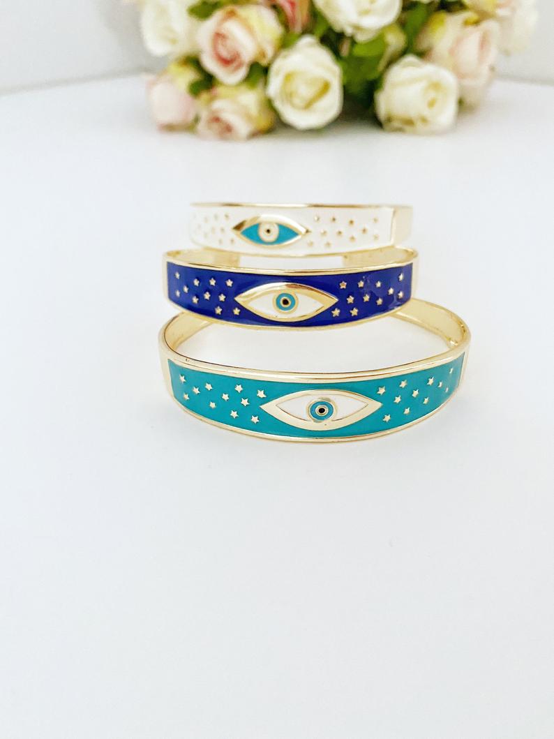 Adjustable Wide Cuff Bracelet featuring a movable Evil Eye charm in blue and gold, perfect for stacking.
