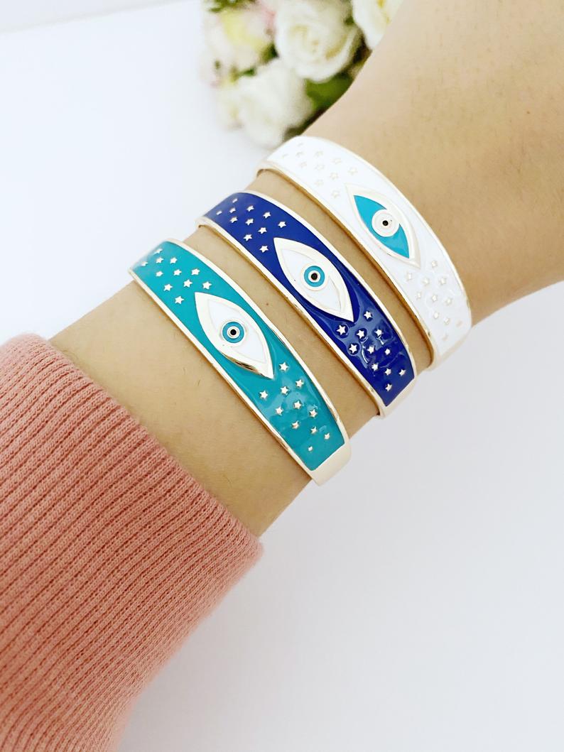 Adjustable Wide Cuff Bracelet featuring a movable Evil Eye charm in blue and gold, perfect for stacking.