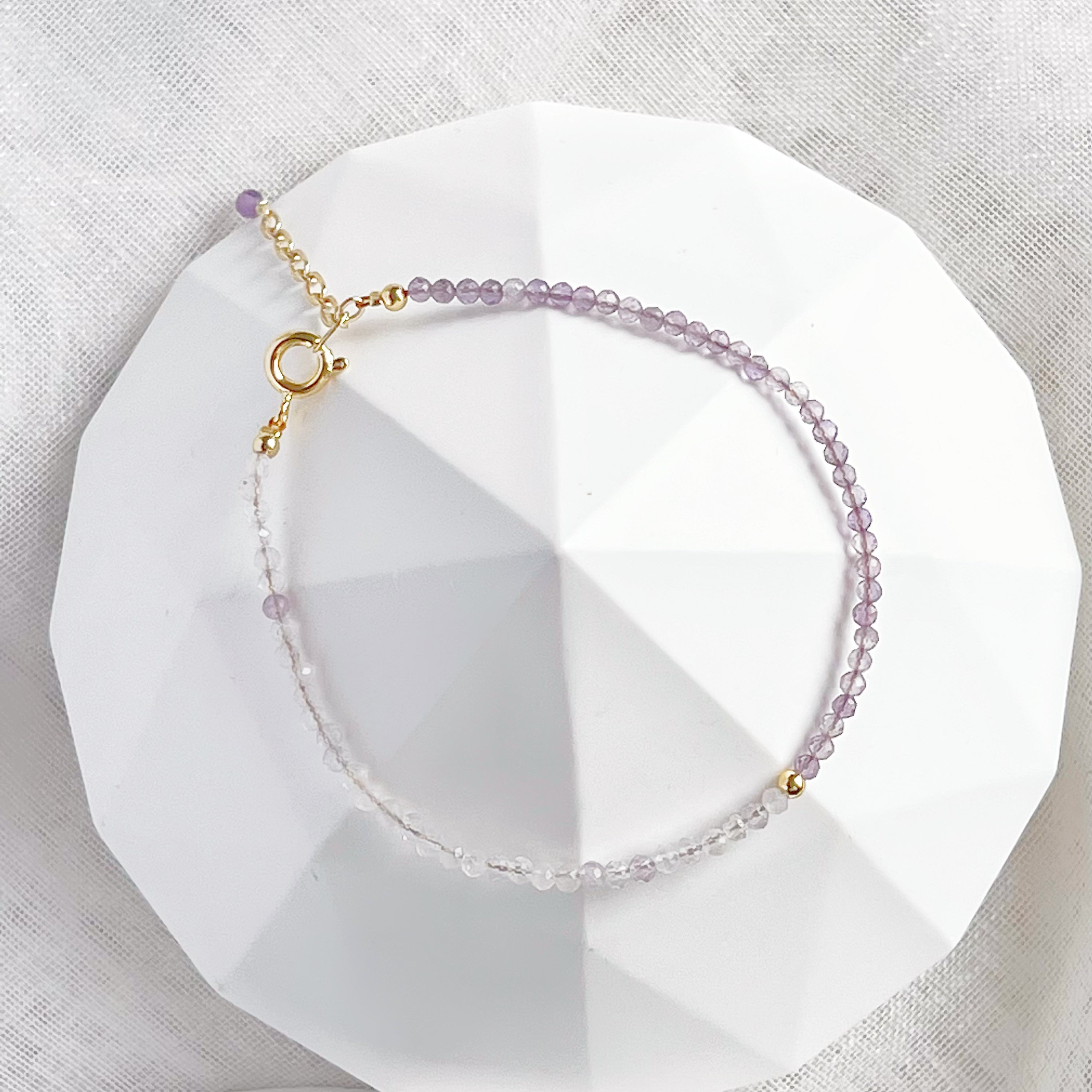 Amethyst and Quartz Beaded Bracelet featuring natural gemstones with gold-plated bronze buckle and chain, elegantly displayed.