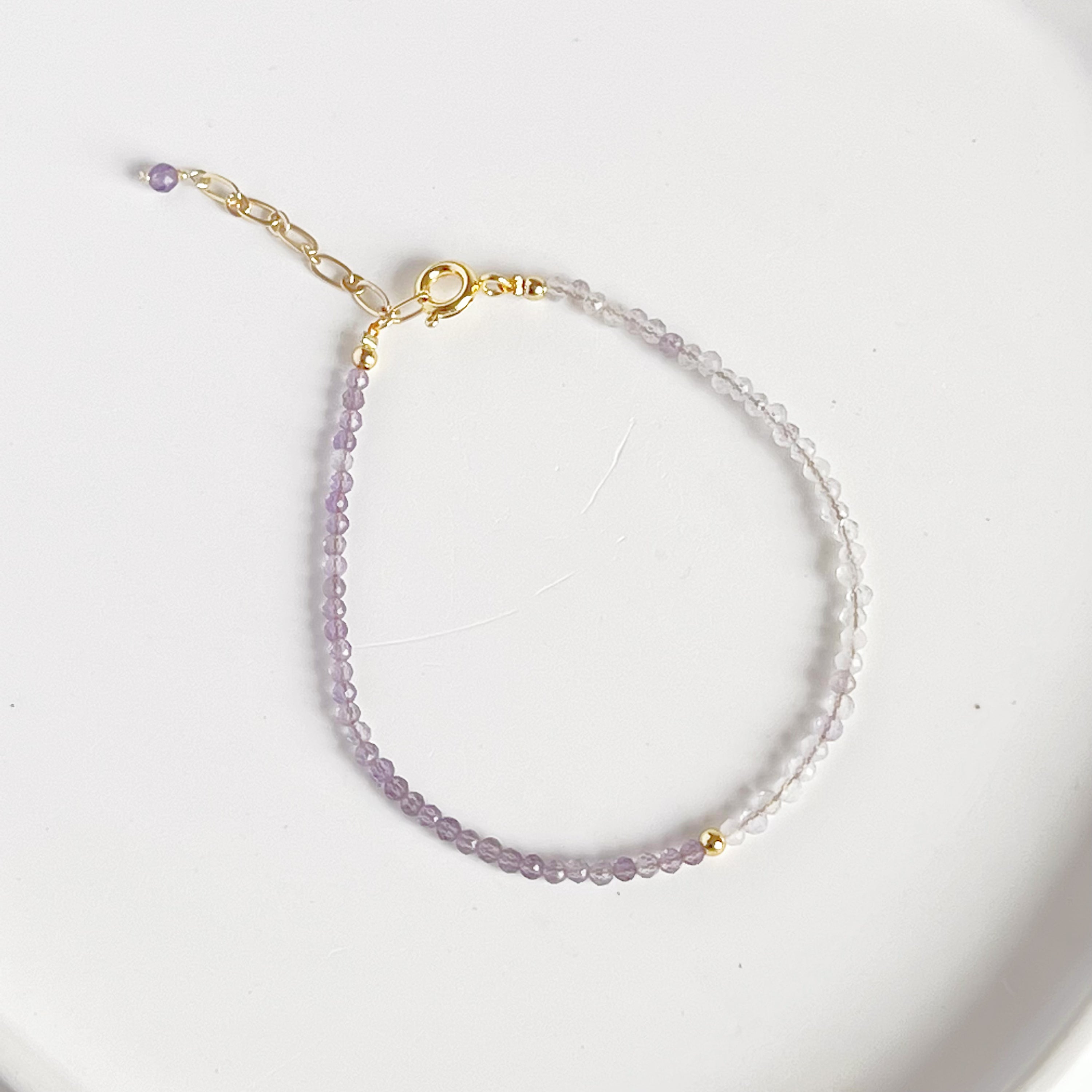 Amethyst and Quartz Beaded Bracelet featuring natural gemstones with gold-plated bronze buckle and chain, elegantly displayed.