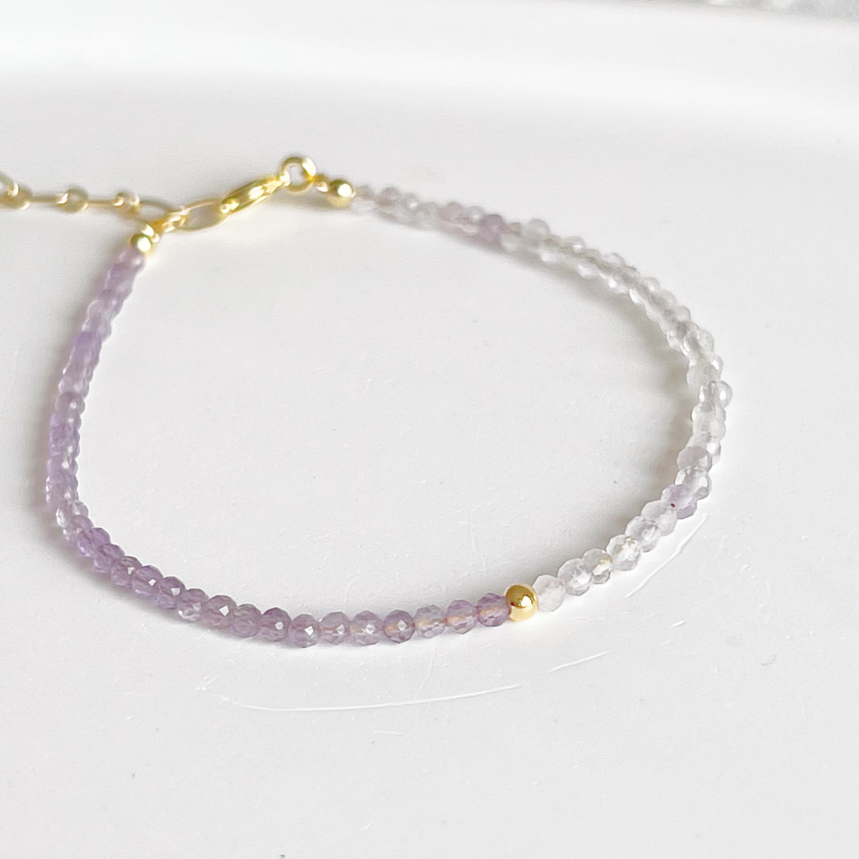 Amethyst and Quartz Beaded Bracelet featuring natural gemstones with gold-plated bronze buckle and chain, elegantly displayed.