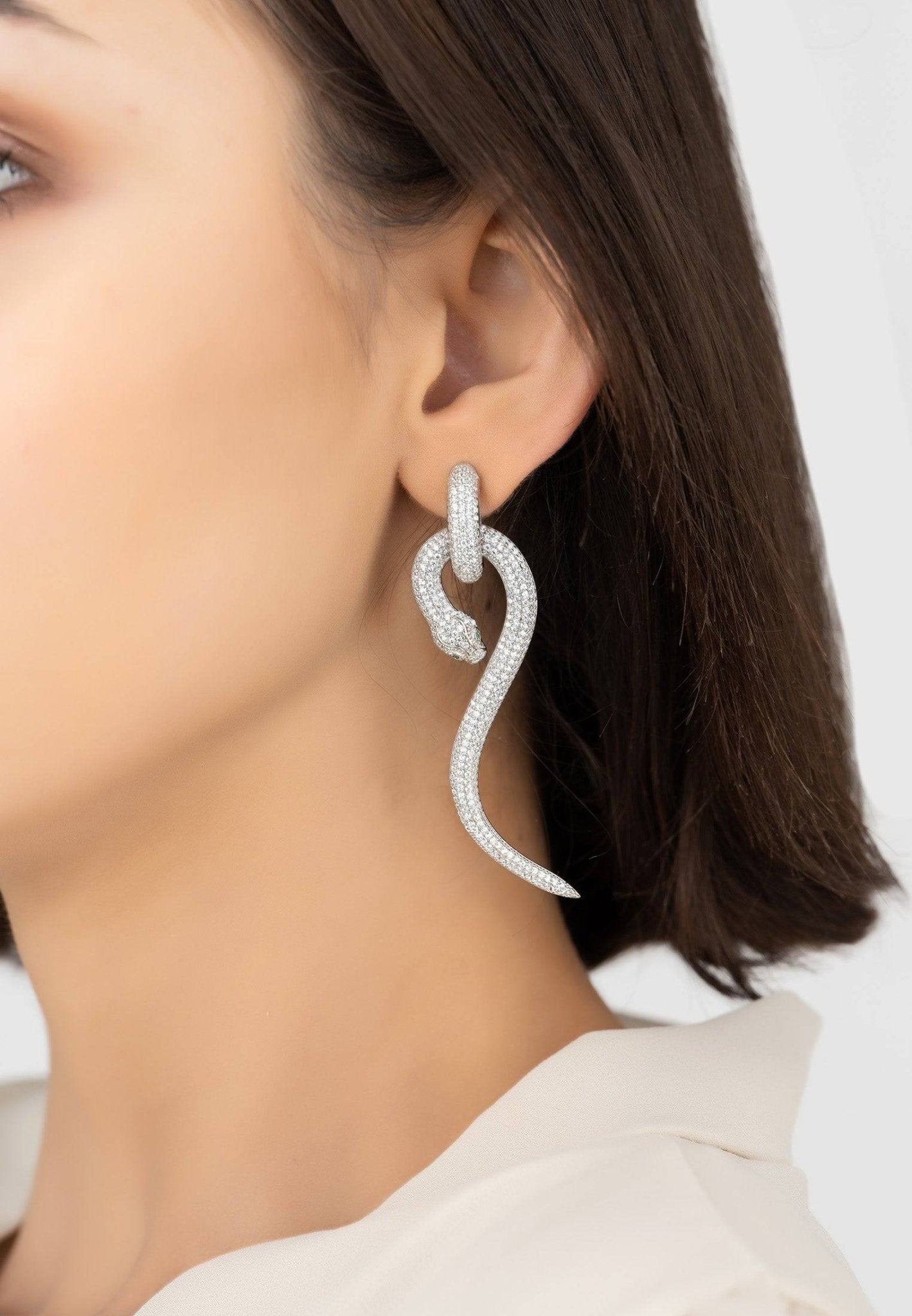 Elegant Anaconda snake drop earrings in sterling silver with sparkling cubic zirconia, showcasing a unique design.