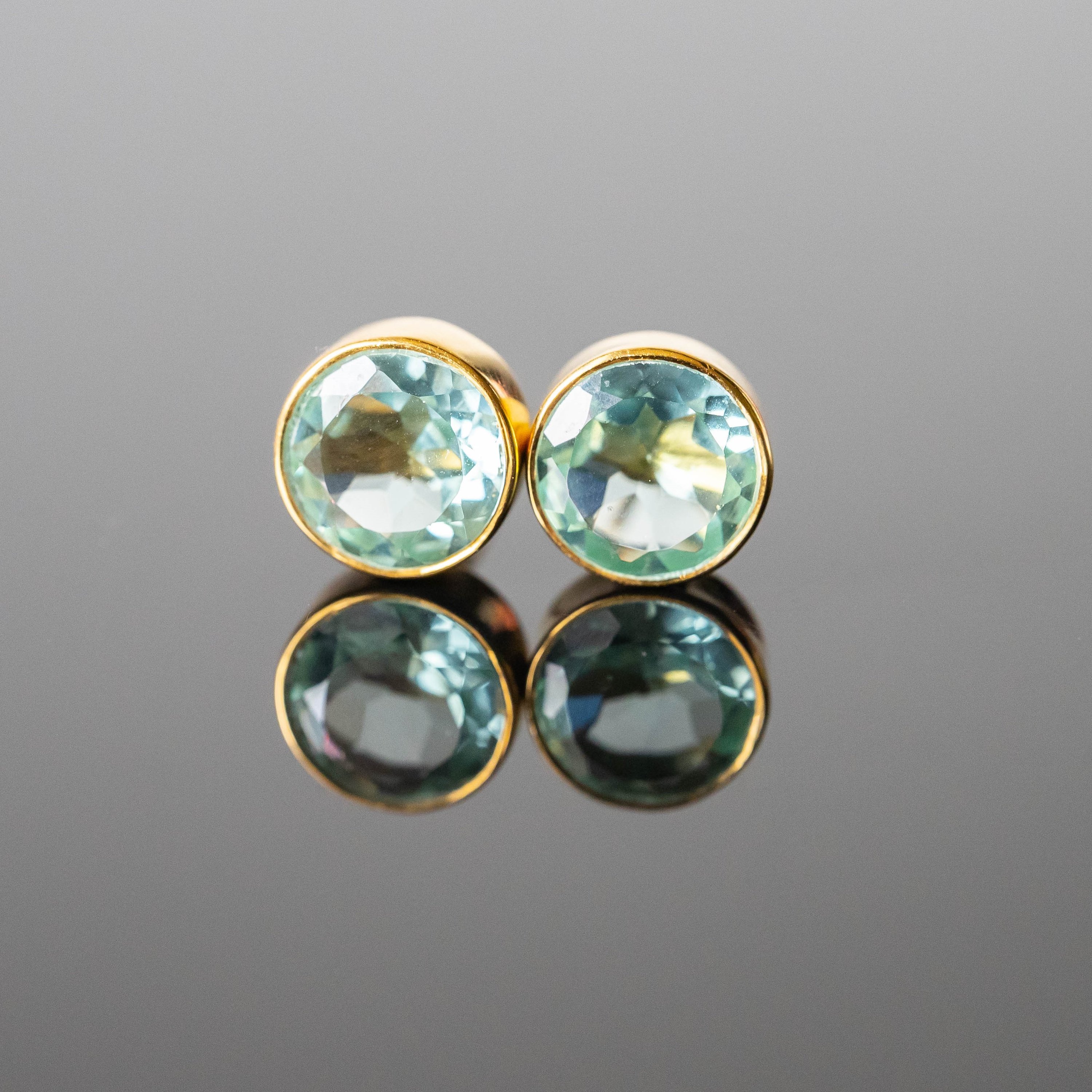 Andrea Aquamarine Round Studs featuring green tone aquamarine stones set in gold-plated 925 sterling silver, elegantly designed for any occasion.