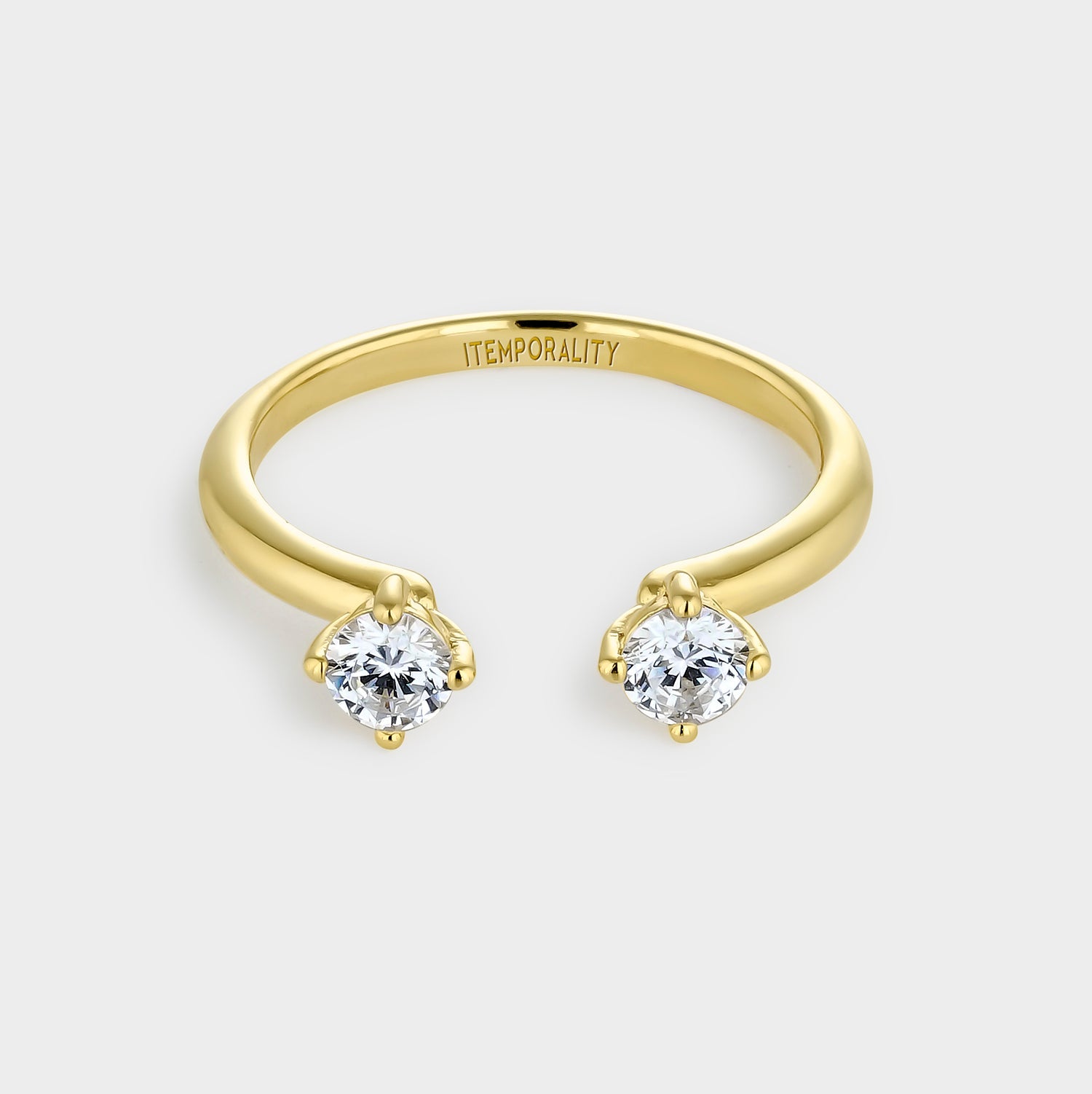 Anillo de plata bañada en oro amarillo con diseño abierto y dos circonitas blancas engastadas en garras.