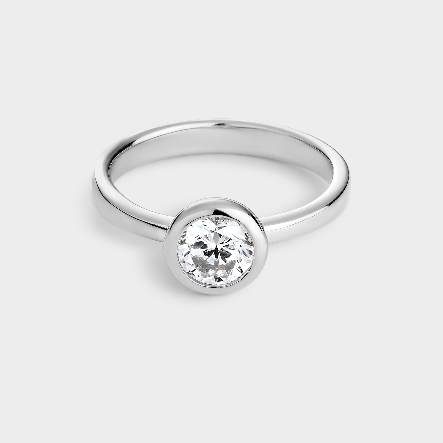 Anillo solitario de plata con circonita de 6 mm engastada en bisel, mostrando su brillo y diseño elegante.