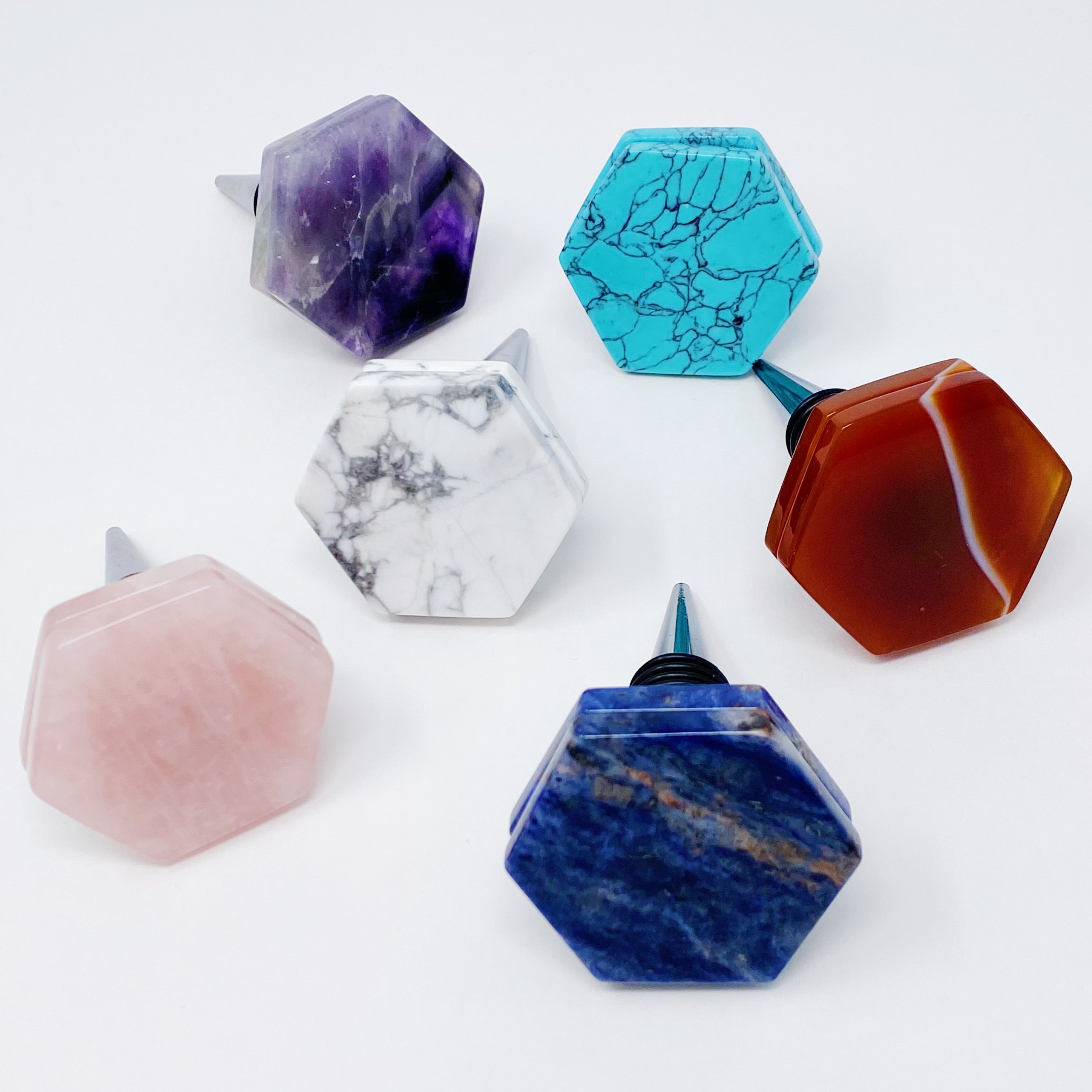 Another Class Hexagon Stone Wine Stopper featuring polished semi-precious stones in a unique hexagon shape, elegantly stacked and presented in a velvet pouch.