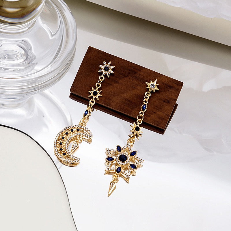 Asymmetric eight-pointed star earrings with sapphire accents, crafted from alloy and rhinestones, showcasing a unique design.