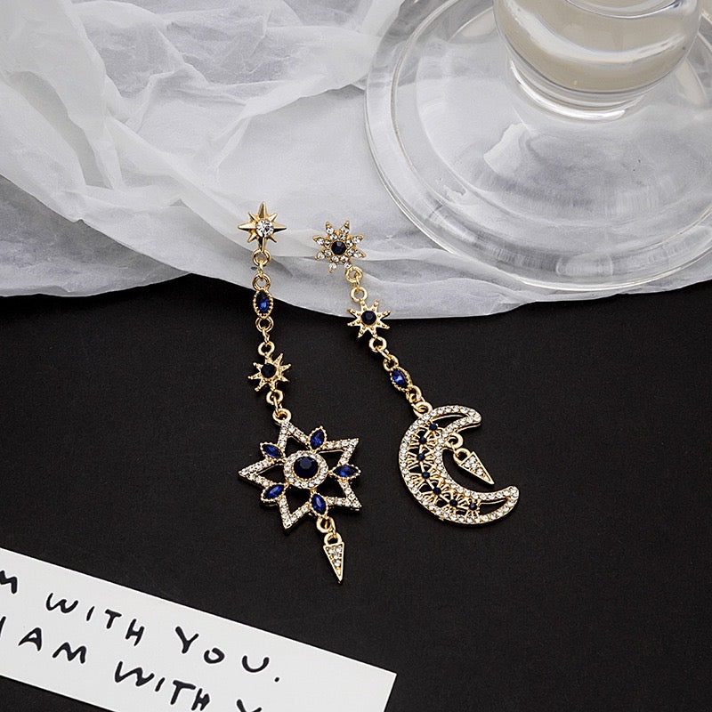 Asymmetric eight-pointed star earrings with sapphire accents, crafted from alloy and rhinestones, showcasing a unique design.