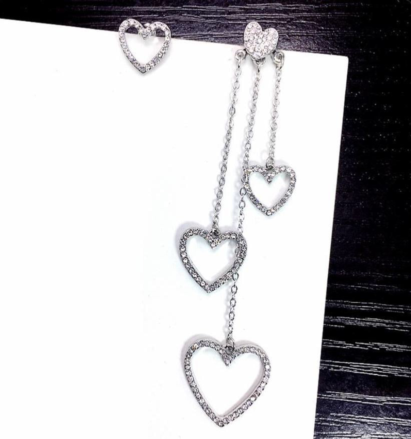 Asymmetric Rhinestone Hearts Tassel Earrings featuring sparkling rhinestones and a unique heart design, elegantly hanging with tassels.