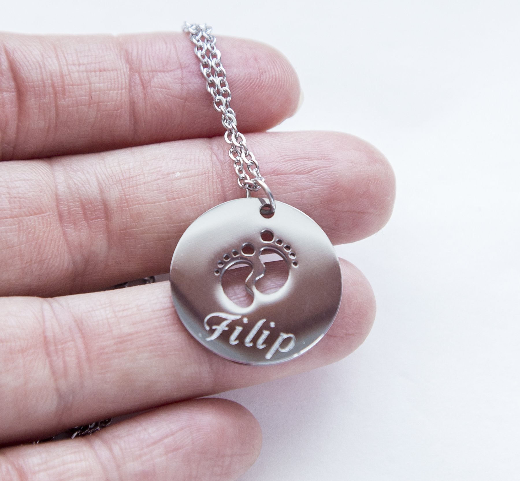 A beautiful stainless steel necklace featuring a baby feet pendant, customizable with engraving for new moms.