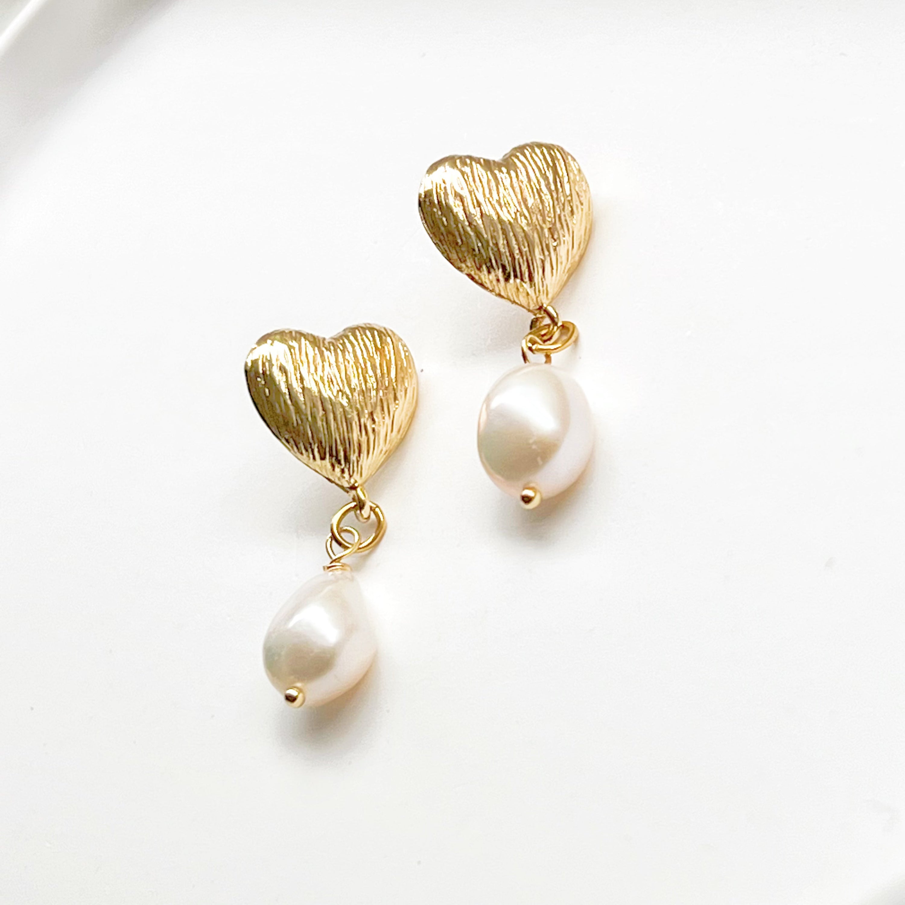 Elegant Baroque Pearl and Gold Heart Earrings showcasing unique teardrop pearls and gold-plated studs.