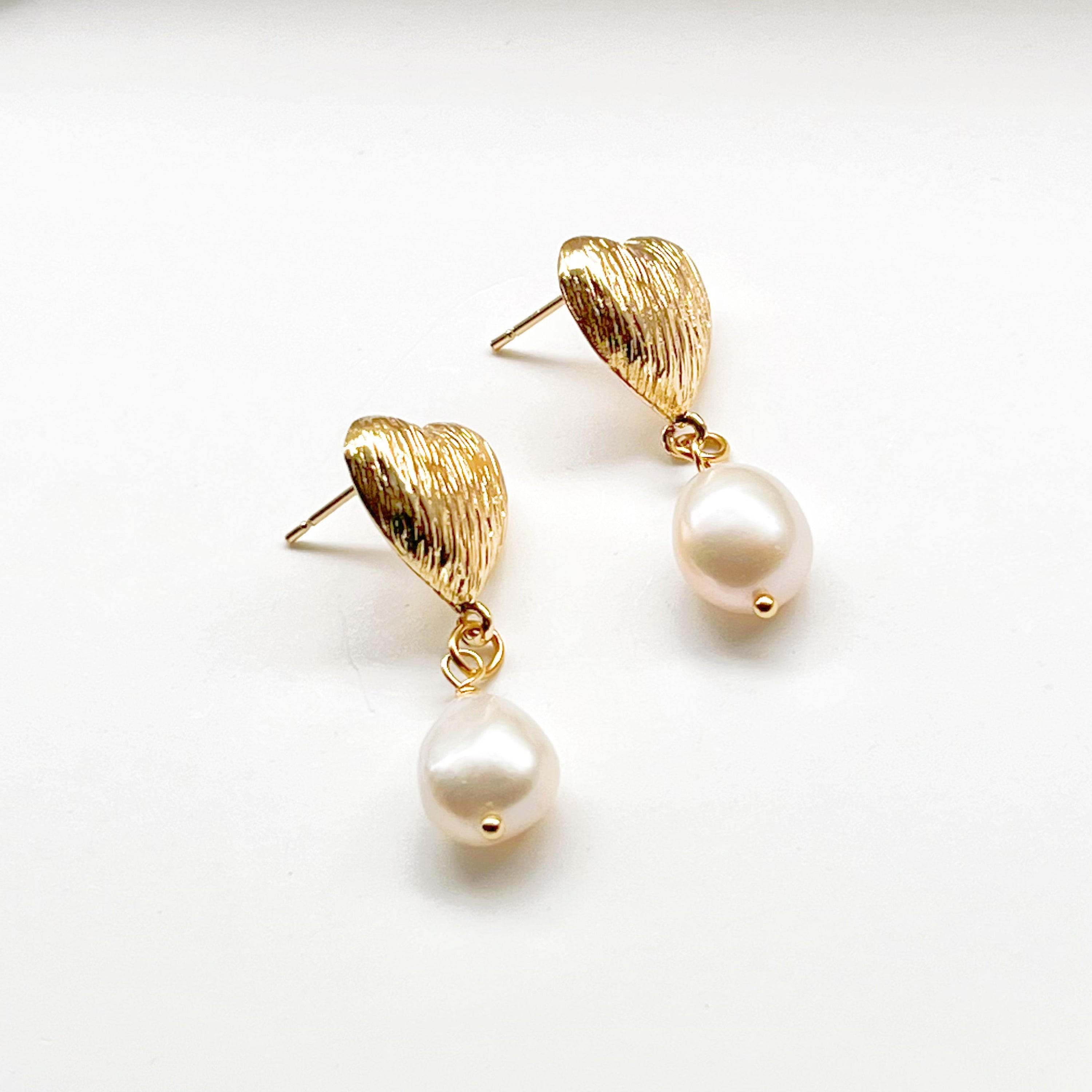 Elegant Baroque Pearl and Gold Heart Earrings showcasing unique teardrop pearls and gold-plated studs.