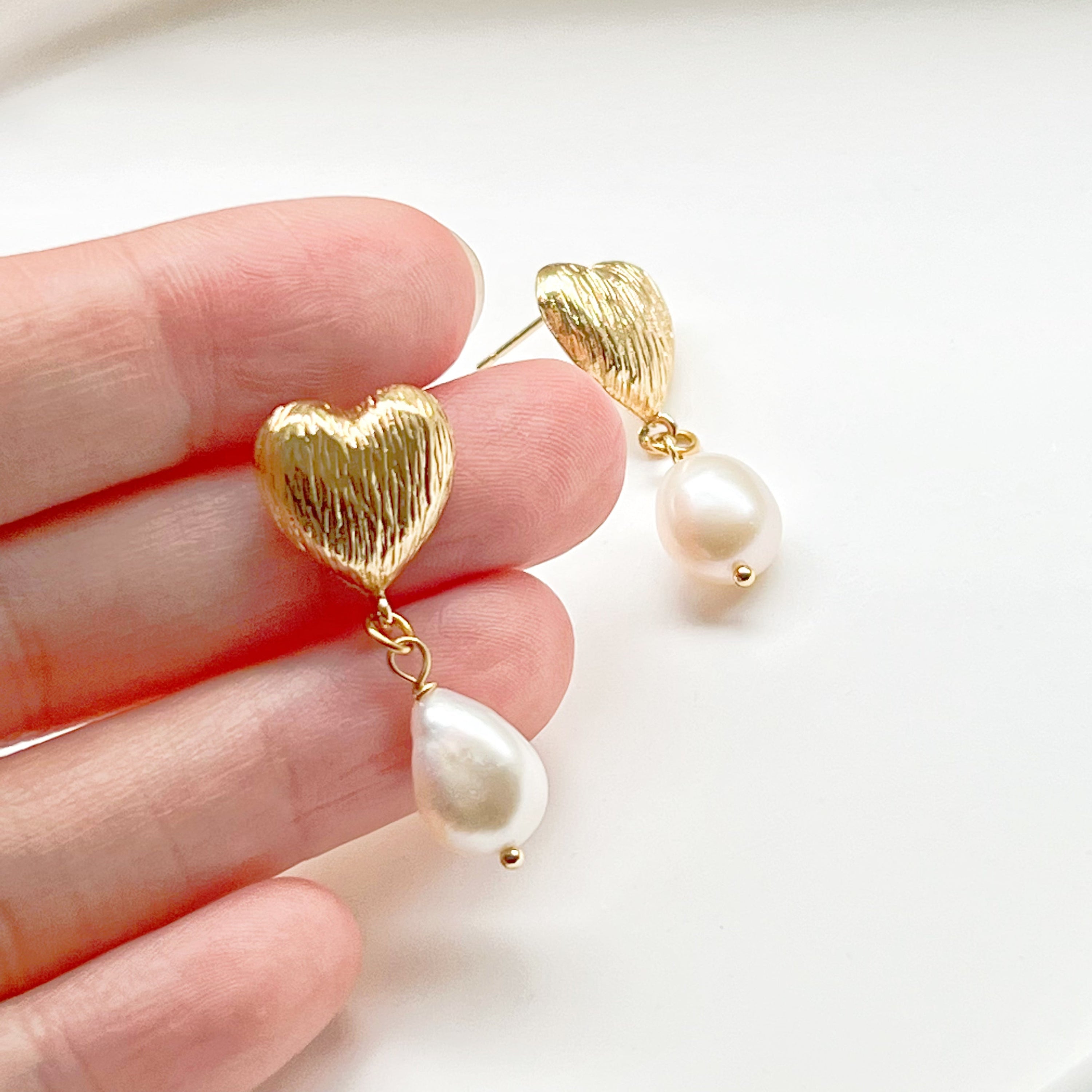 Elegant Baroque Pearl and Gold Heart Earrings showcasing unique teardrop pearls and gold-plated studs.