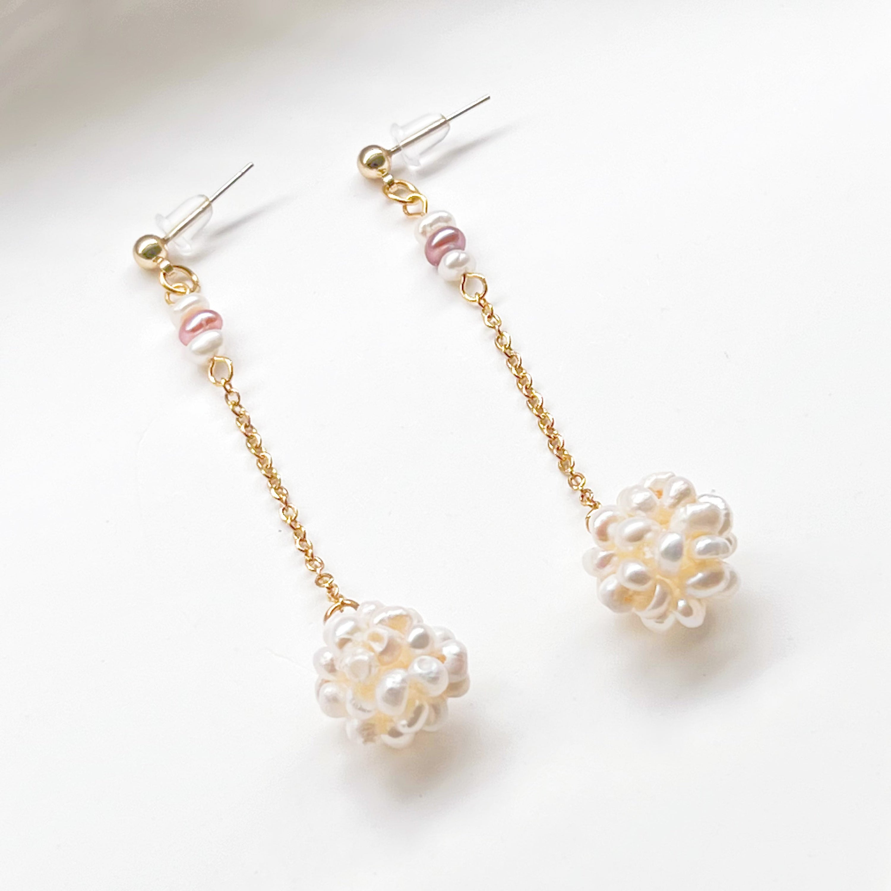 Elegant baroque pearl long drop earrings featuring freshwater pearls and sterling silver studs, showcasing unique shapes and a luxurious design.