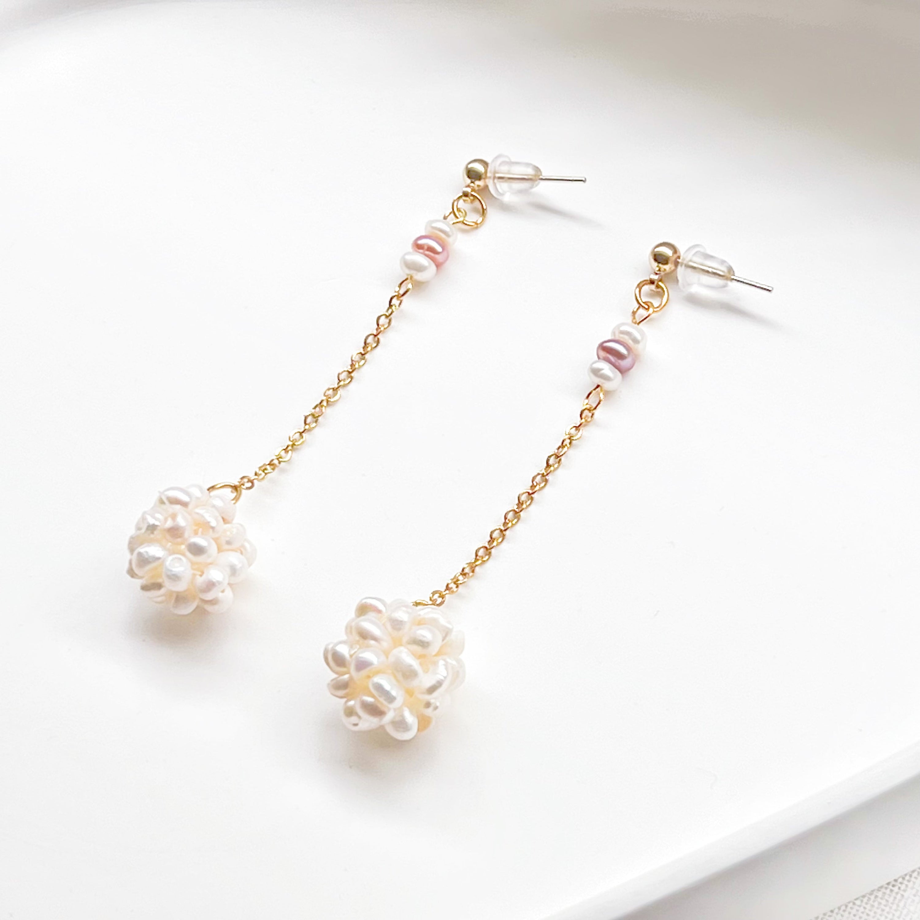 Elegant baroque pearl long drop earrings featuring freshwater pearls and sterling silver studs, showcasing unique shapes and a luxurious design.