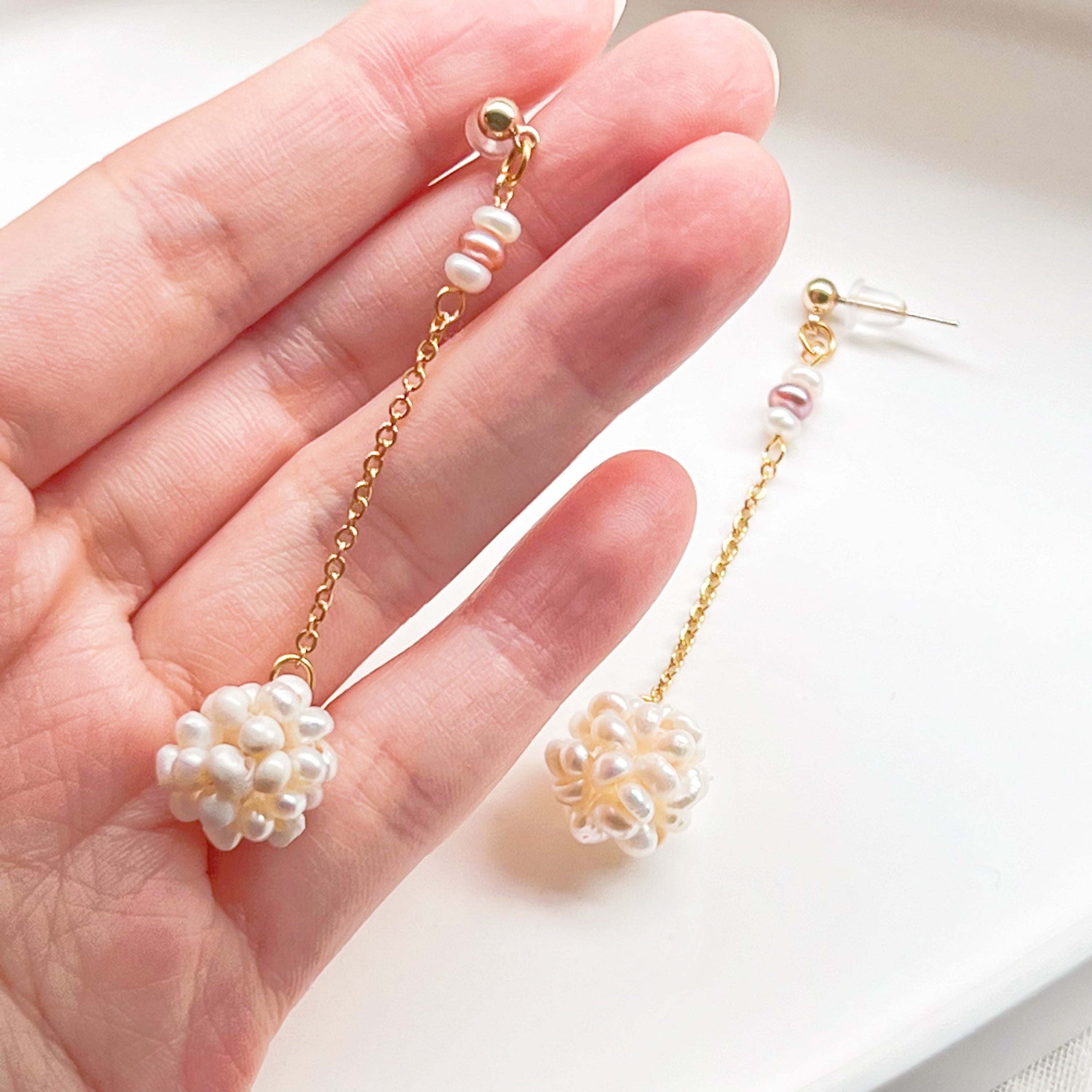 Elegant baroque pearl long drop earrings featuring freshwater pearls and sterling silver studs, showcasing unique shapes and a luxurious design.