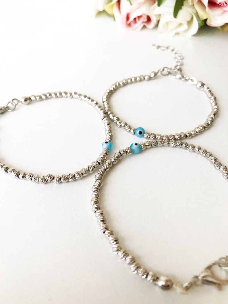 Beaded Evil Eye Bracelet featuring tiny evil eye beads on a rose gold and silver chain, showcasing its adjustable design and handmade craftsmanship.