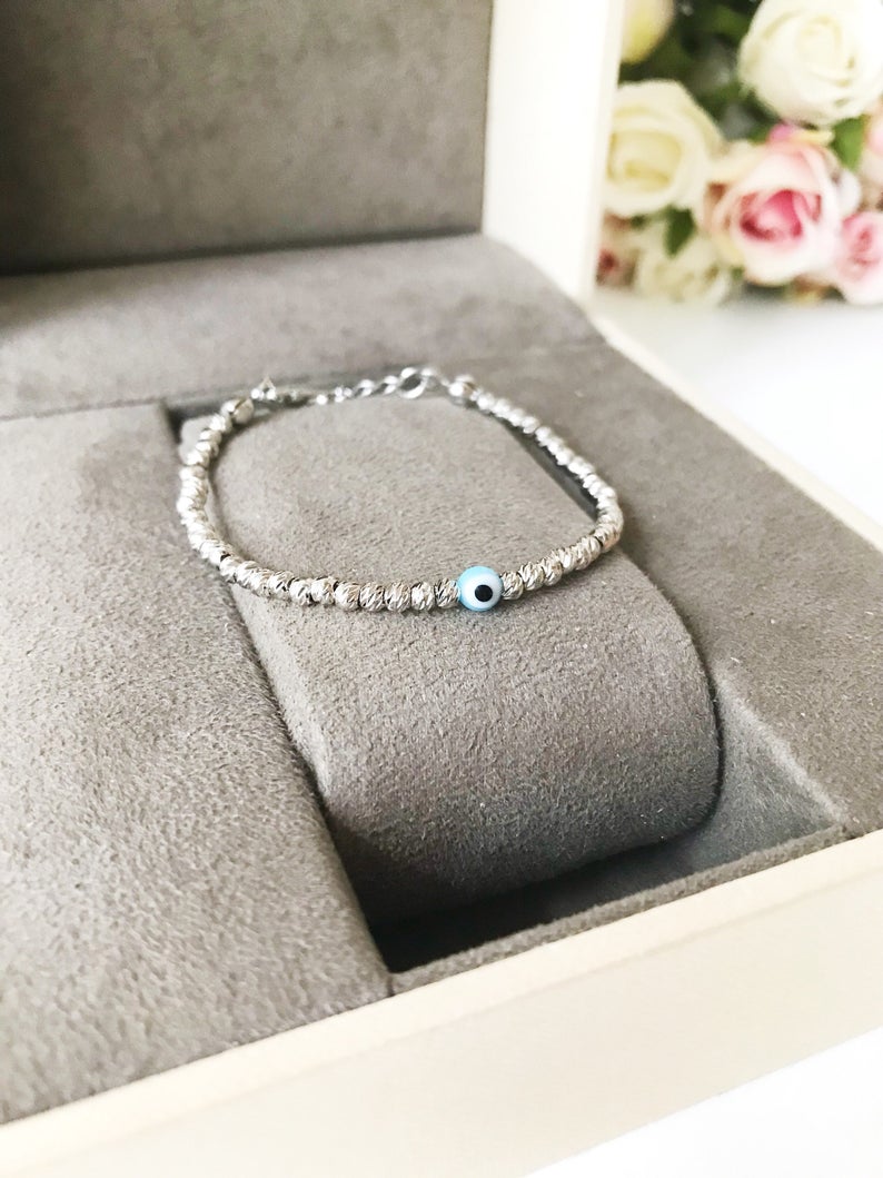 Beaded Evil Eye Bracelet featuring tiny evil eye beads on a rose gold and silver chain, showcasing its adjustable design and handmade craftsmanship.
