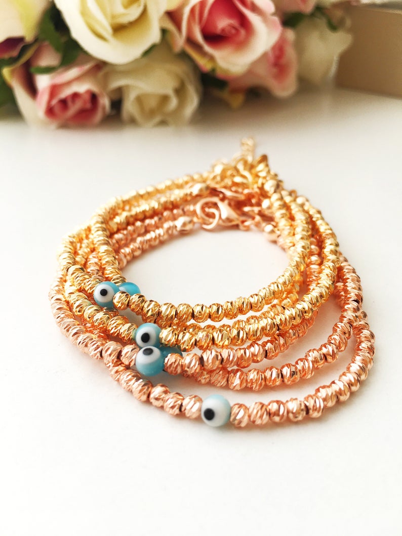 Beaded Evil Eye Bracelet featuring tiny evil eye beads on a rose gold and silver chain, showcasing its adjustable design and handmade craftsmanship.