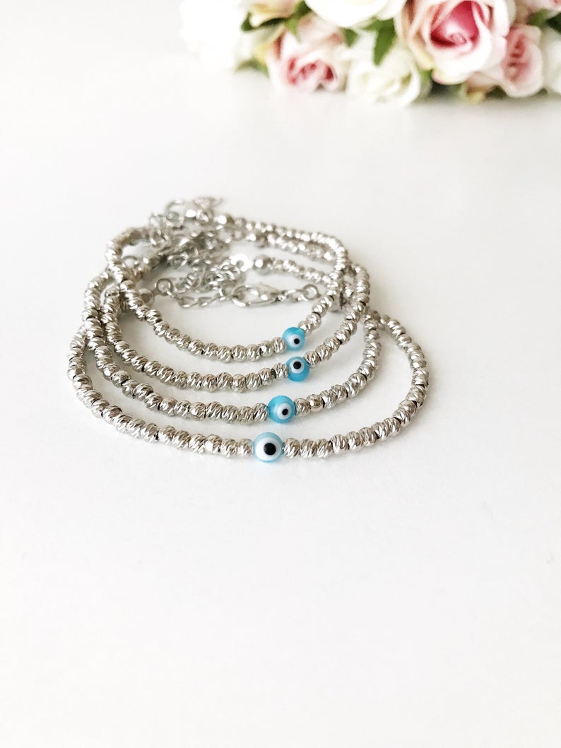 Beaded Evil Eye Bracelet featuring tiny evil eye beads on a rose gold and silver chain, showcasing its adjustable design and handmade craftsmanship.