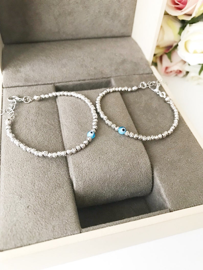 Beaded Evil Eye Bracelet featuring tiny evil eye beads on a rose gold and silver chain, showcasing its adjustable design and handmade craftsmanship.