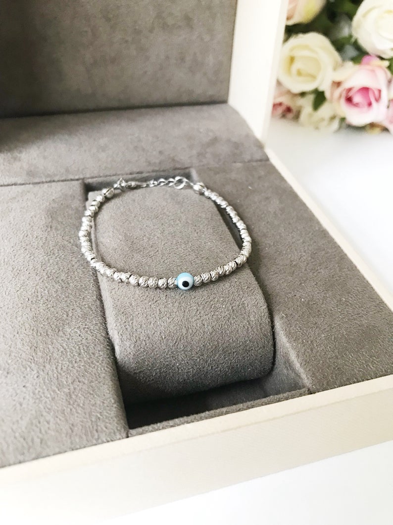 Beaded Evil Eye Bracelet featuring tiny evil eye beads on a rose gold and silver chain, showcasing its adjustable design and handmade craftsmanship.