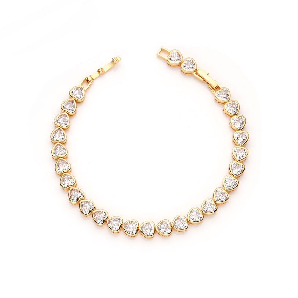 A stunning Bezel Heart Tennis Bracelet featuring a heart-shaped cubic zirconia set in 14k gold plating, perfect for everyday wear.