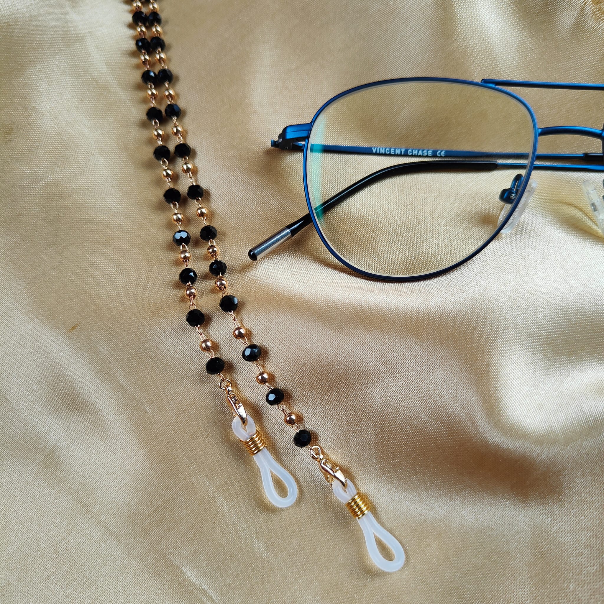 Black Beaded Sunglass Lanyard with Gold and Silver Plating, showcasing elegant design and versatility.