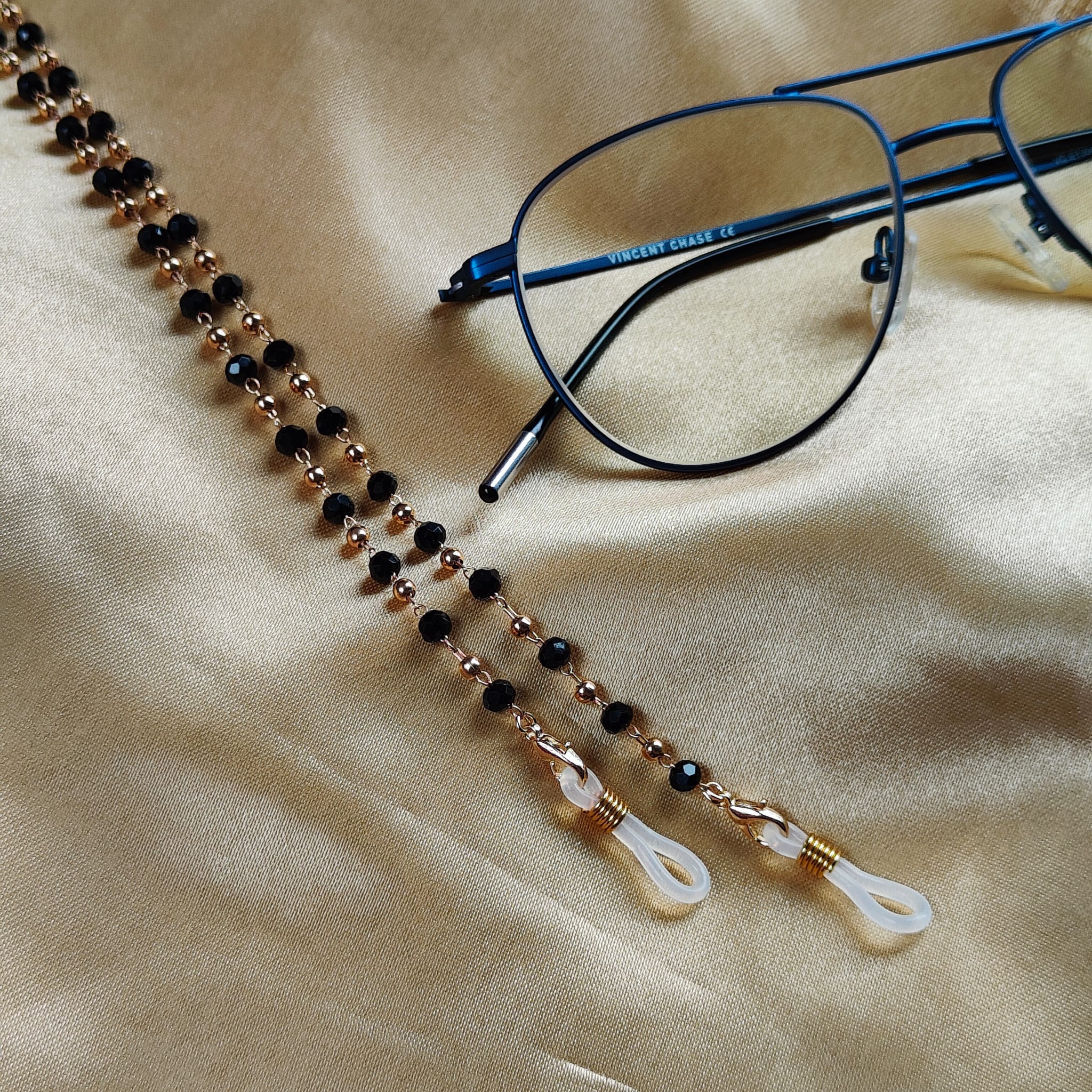 Black Beaded Sunglass Lanyard with Gold and Silver Plating, showcasing elegant design and versatility.