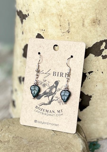 Black etched mini leaf dangle earrings featuring intricate Czech glass craftsmanship with a whimsical owl design.
