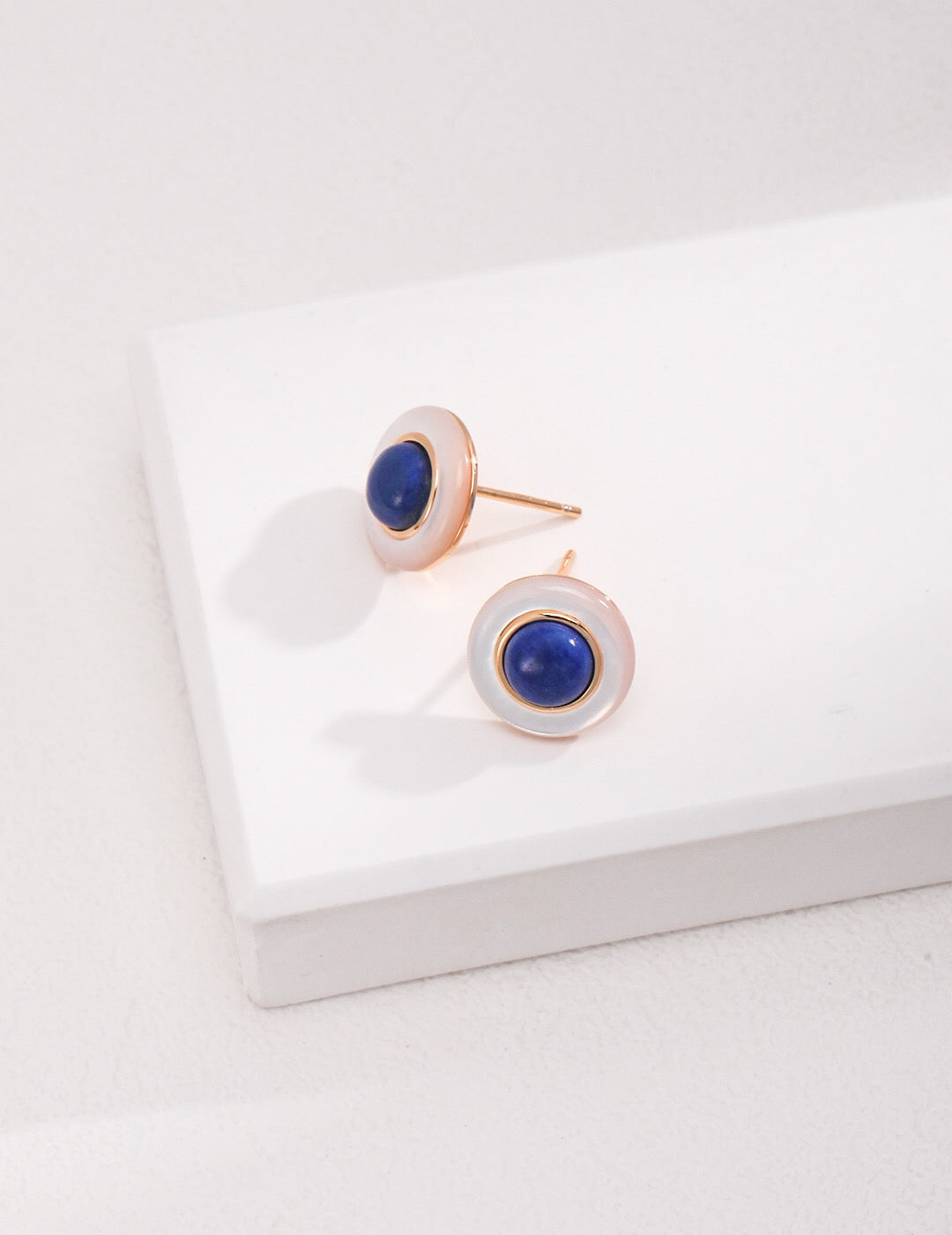Elegant blue and white lapis lazuli earrings with gold vermeil detailing, showcasing their unique handcrafted design.